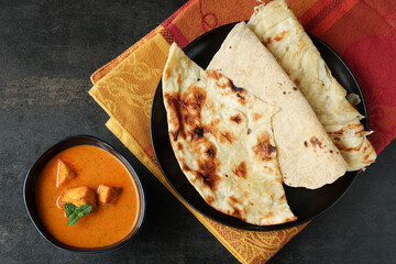Tandoori Roti whole wheat flat bread with Indian curry butter chicken and butter paneer . Indian...