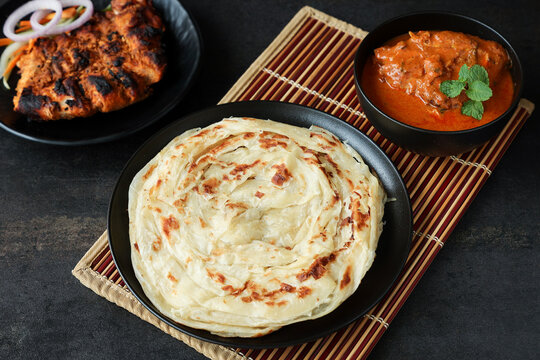 Kerala parathas / porotta / roti / parotta / barotta/ naan layered flatbread made from maida or whole wheat flour. Eat with spicy Asian chicken or beef or egg curry gravy. breakfast dish. Indian food.