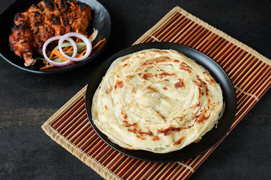 Kerala parathas / porotta / roti / parotta / barotta/ naan layered flatbread made from maida or whole wheat flour. Eat with spicy Asian chicken or beef or egg curry gravy. breakfast dish. Indian food.