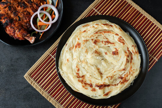 Kerala parathas / porotta / roti / parotta / barotta/ naan layered flatbread made from maida or whole wheat flour. Eat with spicy Asian chicken or beef or egg curry gravy. breakfast dish. Indian food.
