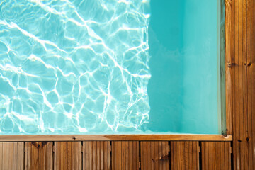 Top view background with wooden board on swimming pool. Horizontally. 