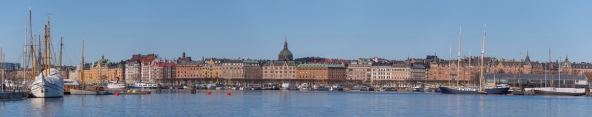 Fototapeta na wymiar Panorama view over the bay Ladugårdsviken, piers with boats, apartment and hotel houses and a sunny winter day in Stockholm