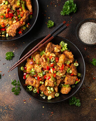 Stir fry salt and pepper pork loin with herbs in black bowl. Asian food