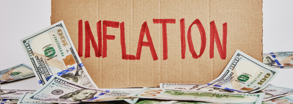 World Economic Crisis And Inflation Concept, Cardboard Sheet With Word Inflation And Us Dollar Banknotes, Rising Prices For Consumer Goods And Services