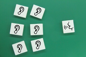 white squares with ear and speaking icons. the concept of speaking and listening