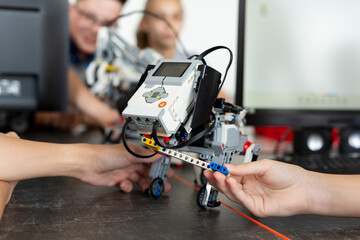 Children play with a robot dog in a robotics lesson