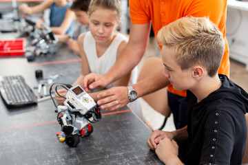 Fototapeta na wymiar Kids working with teacher on their robot education project