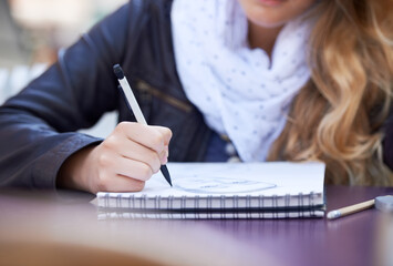 Sketching in her free time. A young woman drawing in her notepad.