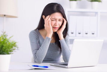 Stressed young  woman suffering from headache after computer work