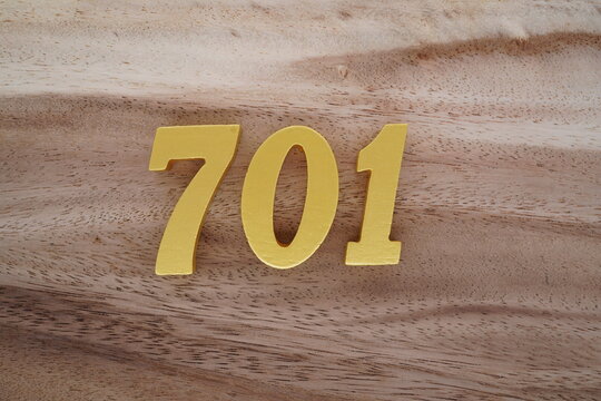 Golden Arabic numerals on a real brown and white wooden floor number 701