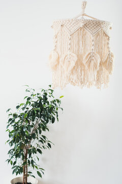 Lapm in the style of Boho made of cotton threads in natural color using the macrame technique for home decor. close up