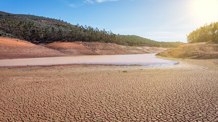 Landscape of low water and dry land in advance, severe drought in the reservoir of Portugal. Ecological disaster, soil dehydration. desert, drought,