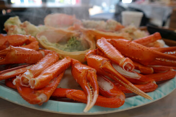 Steamed red snow crab is served on a round plate.