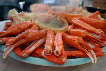 Steamed red snow crab is served on a round plate.