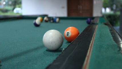 object focus of white billiard ball and number 5 ball on blur background