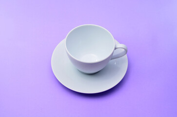 White empty coffee cup on a purple background.