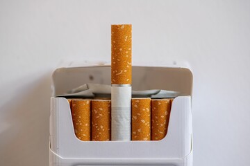 open pack of cigarettes on white ground in close up