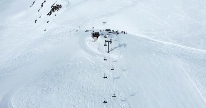 Vue a&eacute;rienne en drone de l'arriv&eacute;e d'un t&eacute;l&eacute;si&egrave;ge dans une station de ski en Savoie dans les Alpes en France - Aerial drone view of a ski lift arrival in the Alps, Moutains in Savoie, France 