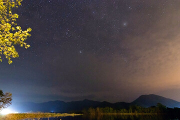 Night landscape with dark silhouette of mountains and sky with star. Extreme long exposure image showing star.