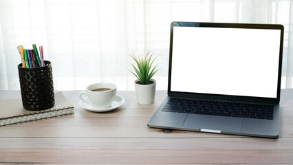 Fototapeta premium Work form home or online learning concept on wooden table desk with blank screen laptop computer and coffee cup, stationery, social distance during quarantine, self-isolation, online education concept