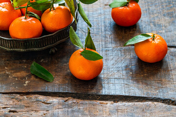 Mandarin oranges with green leaves on wooden table