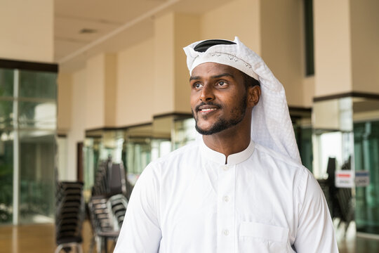 Portrait of African Muslim man wearing religious clothing an scarf at office while thinking
