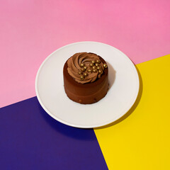 a cake on a white saucer on a colored background. holiday and party concept