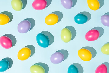 Colorful pattern made of Easter eggs on pastel blue background. Creative holiday wallpaper concept....