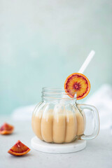 orange milkshake from red oranges and vanilla in a glass mug
