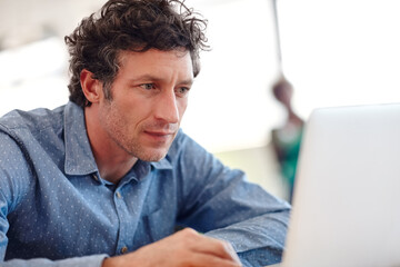 Fully focused. Cropped shot of a handsome businessman working on a laptop.