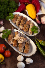 Pork rolls with mushrooms, meat rolls surrounded by greenery and vegetables. Ukrainian dishes is called krucheniki