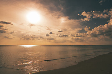 Fototapeta na wymiar Beautiful sand beach with dramatic clouds and sun in the sky - Koh Lanta Thailand