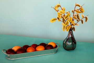Rustic style festive decor. Easter decoration with brown eggs and green yellow catkins vase.
