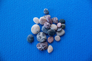 Top view of pebble stones on blue background.