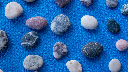 Top view of pebble stones on blue background.