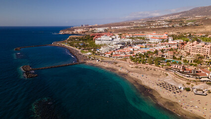 Fototapeta premium El Duque beach in Tenerife, with its incredible turquoise water and golden sand, is a favourite for lovers of the sun and relaxation, and has all the amenities
