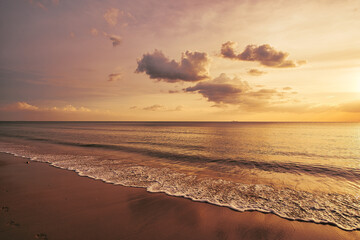 Beautiful sand beach with waves, wonderful clouds in the sky during a dramatic sunset - Koh Lanta Thailand