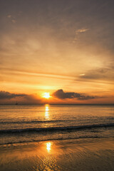 Beautiful beach with waves, wonderful clouds in the sky during a dramatic sunset reflecting in the sand - Koh Lanta Thailand