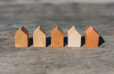 a set of tiny wooden houses in a row. concept image for wood as a renewable and sustainable building material for modular timber architecture. 