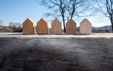 a set of tiny wooden houses in a row. concept image for wood as a renewable and sustainable...