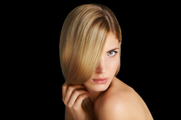 Soft and silky hair. Portrait of a beautiful blonde woman isolated on black.