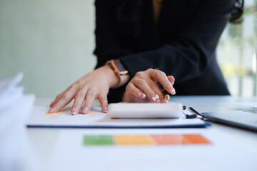 Close up Business woman hand using calculator to calculate the company's financial results and budget. Account Audit Concept.