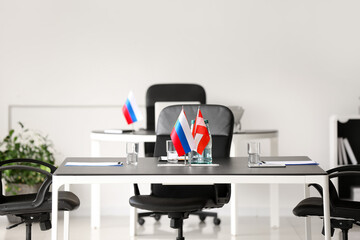 Flags of Austria, Spain and Russia on table in conference room