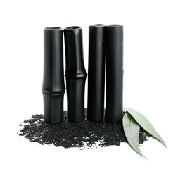 Black bamboo sticks and activated carbon powder on white background