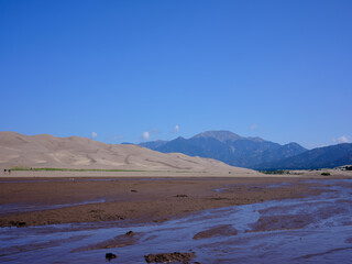 Dried sandy and muddy creek bed at the foot of the great sand dunes in Colorado