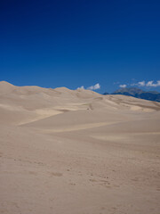 Vertical image of a perfect summer day of the Great Sand Dunes near the San Juan Mountains of Colorado