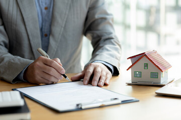 The salesperson of the housing estate in the project is preparing and verifying the contract of sale for the customer who will enter the contract. Concept of selling housing estates and real estate.