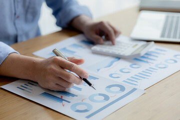 Business man pointing to a chart document showing company financial information, He sits in a private office, a document showing company financial information in chart form. Financial concepts