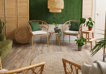 Interior of stylish living room with wicker chairs, table and houseplants