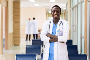 Portrait of African American doctor standing cross hand with big smile inside the hospital ward...